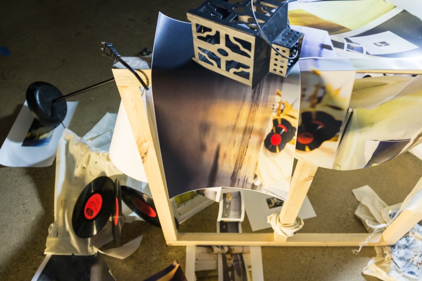 Ruins for Tomorrow, 2016 | Printed digital photographs, silk screen, canvas frame, vinyl records, video cassette, binoculars, surveillance camera, muslin, lamp stand, lantern, broken light bulb, and light kit 